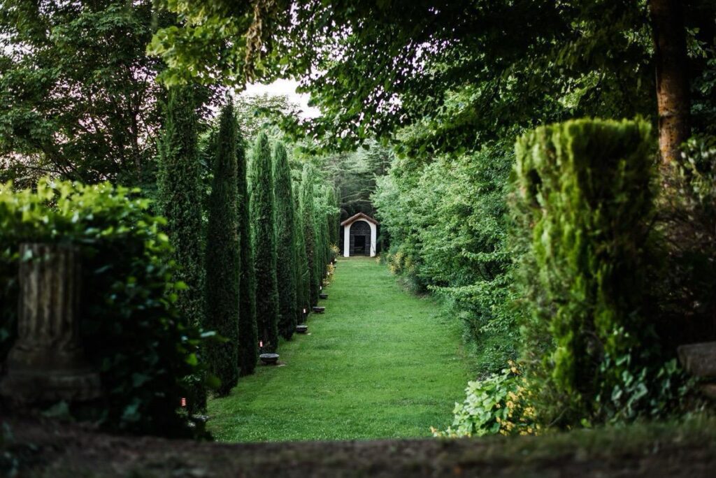Viale alberato tra le siepi nel parco di Villa Massimo